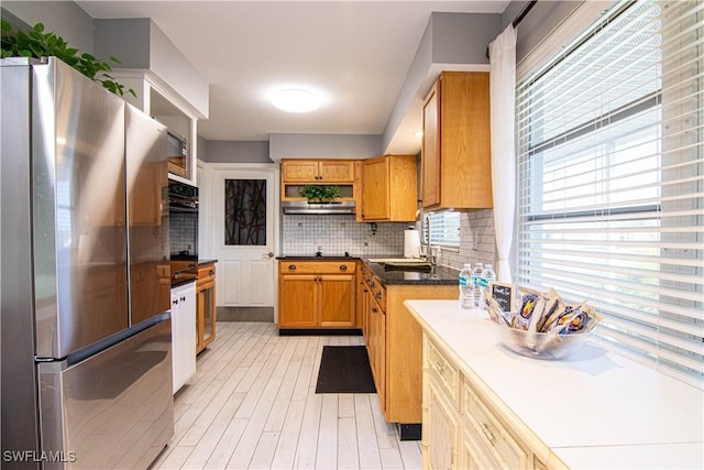 kitchen featuring backsplash, sink, and appliances with stainless steel finishes