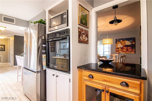 kitchen featuring pendant lighting, stainless steel appliances, and light hardwood / wood-style flooring