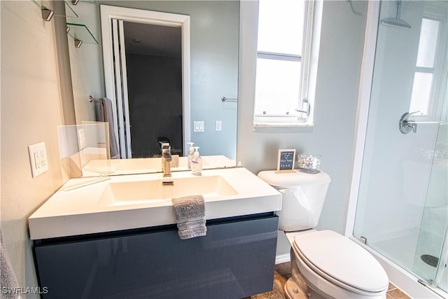 bathroom with vanity, a shower with shower door, and toilet