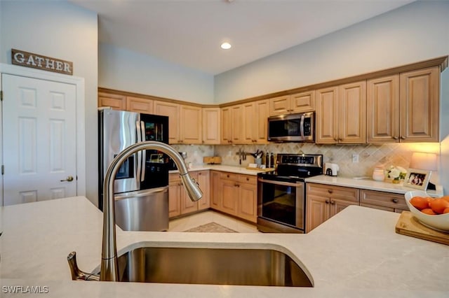 kitchen with backsplash, light brown cabinets, sink, and appliances with stainless steel finishes