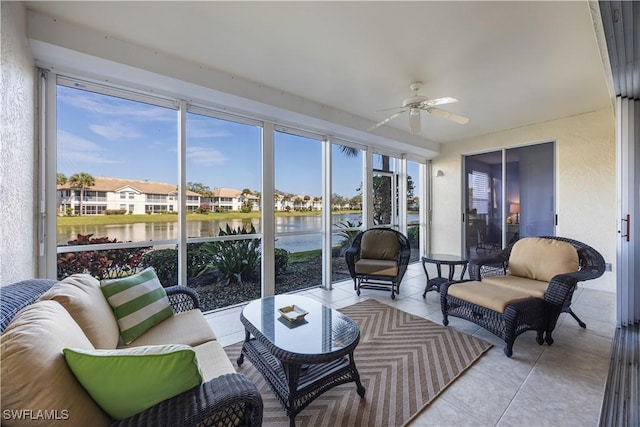 sunroom / solarium with ceiling fan and a water view