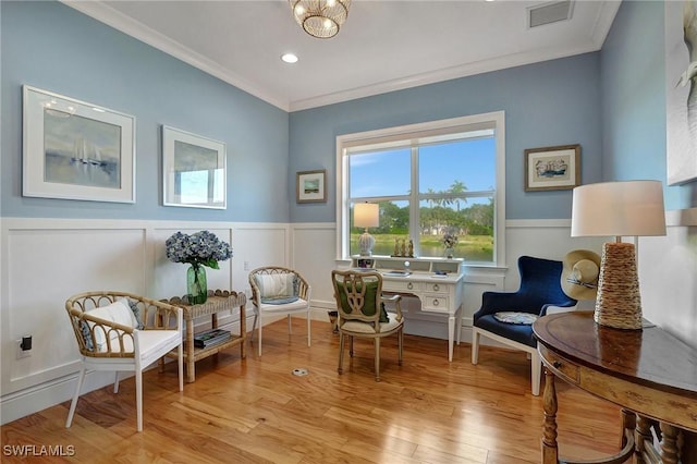 sitting room featuring light wood-type flooring and crown molding