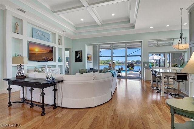 living room with light hardwood / wood-style flooring, beamed ceiling, a healthy amount of sunlight, and coffered ceiling