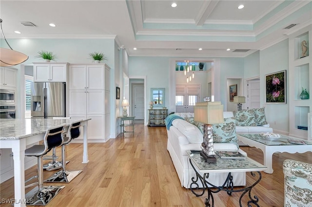 living room featuring beamed ceiling, light wood-type flooring, ornamental molding, and a towering ceiling