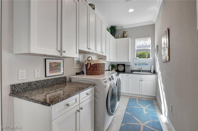 washroom with cabinets, ornamental molding, sink, light tile patterned floors, and washing machine and dryer