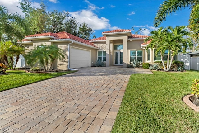 mediterranean / spanish home featuring french doors, a front lawn, and a garage