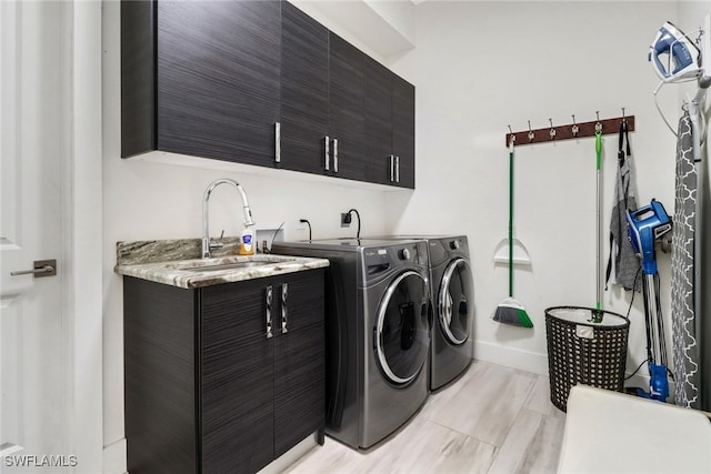 washroom with washer and dryer, sink, and cabinets