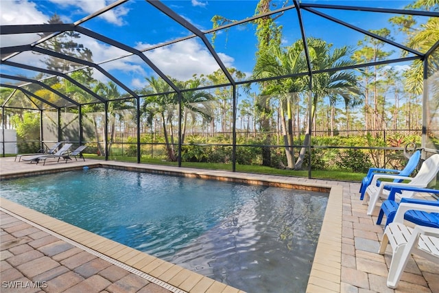 view of pool with glass enclosure and a patio area