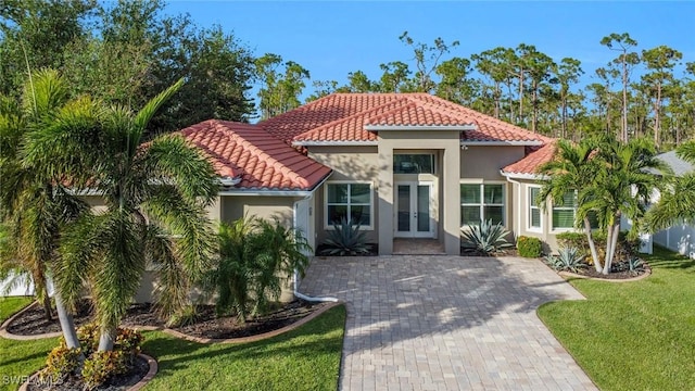 mediterranean / spanish house featuring a front yard and french doors