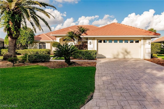 mediterranean / spanish-style house featuring a garage and a front yard