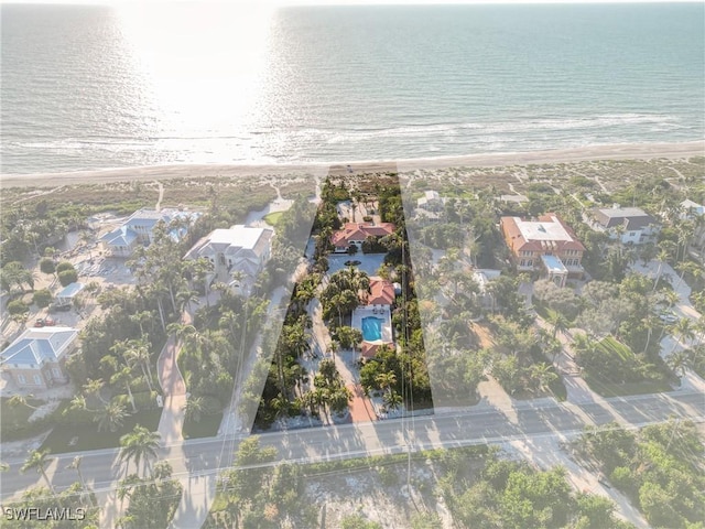 birds eye view of property with a water view and a beach view