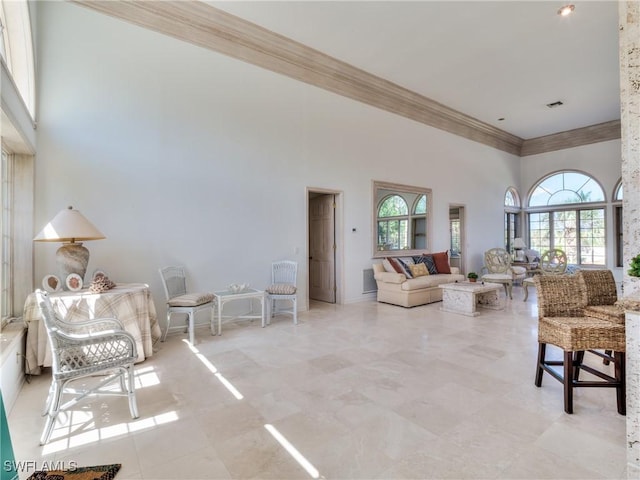 living room with a high ceiling and ornamental molding