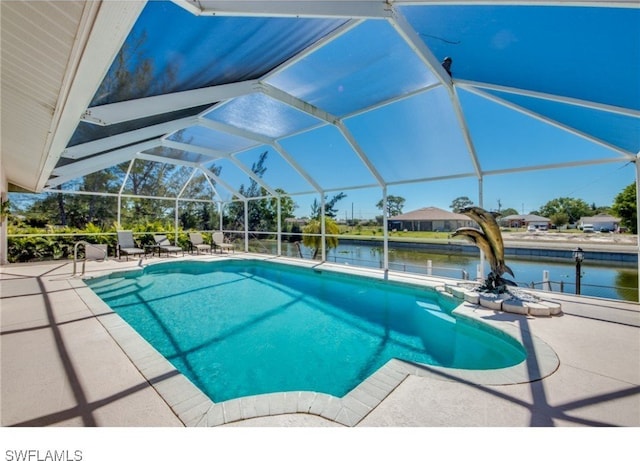 view of pool featuring glass enclosure, a water view, and a patio