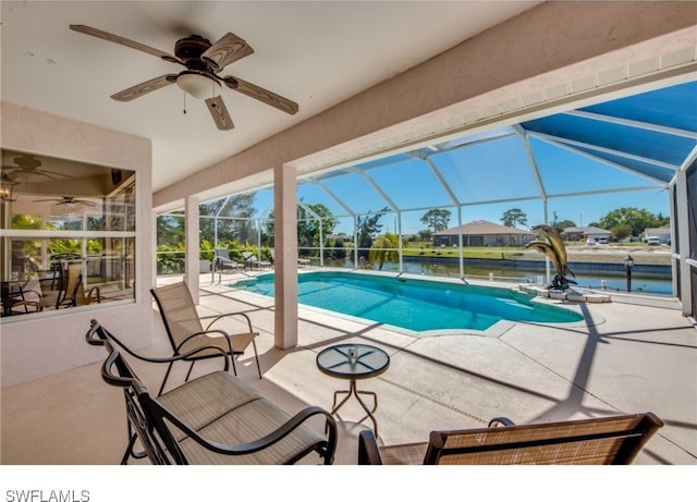 view of pool featuring ceiling fan, a water view, a patio, and glass enclosure