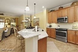 kitchen featuring pendant lighting, a kitchen breakfast bar, sink, an island with sink, and stainless steel appliances