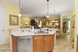 kitchen featuring pendant lighting, a center island with sink, sink, crown molding, and stainless steel dishwasher