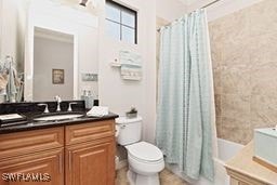 full bathroom featuring vanity, shower / tub combo, and toilet