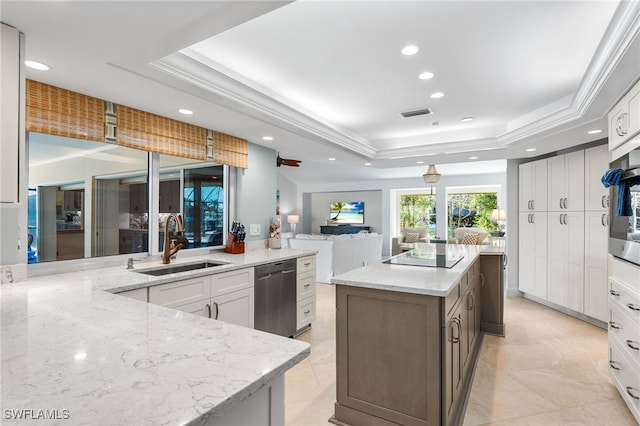 kitchen with white cabinetry, a raised ceiling, and sink