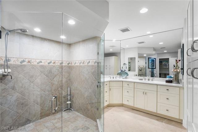 bathroom featuring a shower with door, vanity, and tile walls