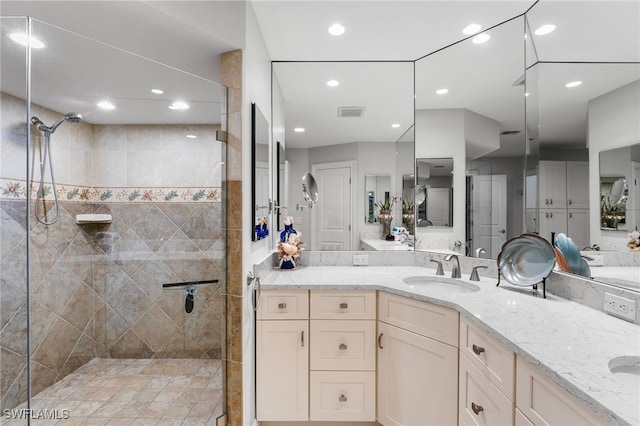 bathroom featuring a tile shower and vanity