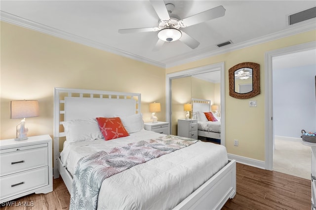 bedroom with a closet, hardwood / wood-style flooring, ceiling fan, and crown molding