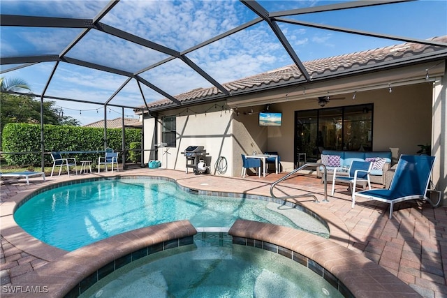 view of swimming pool with a patio, outdoor lounge area, an in ground hot tub, a lanai, and ceiling fan