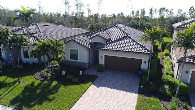 mediterranean / spanish-style house featuring a garage and a front lawn