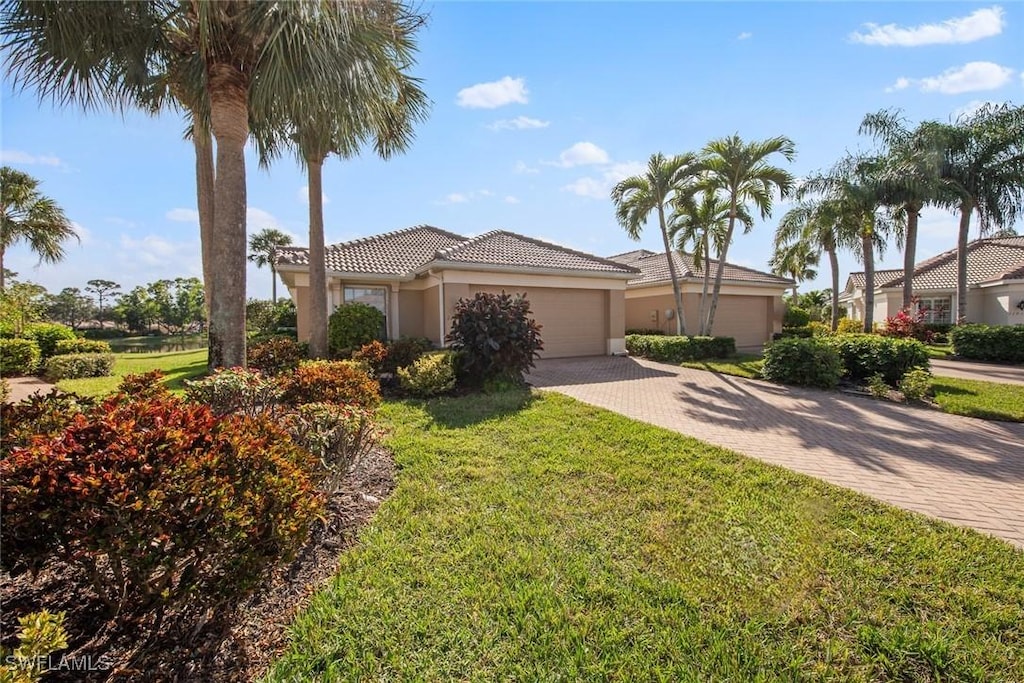 mediterranean / spanish home with a front yard and a garage