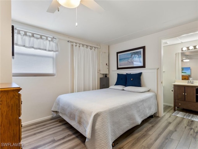 bedroom with ensuite bathroom, ceiling fan, light hardwood / wood-style floors, and sink