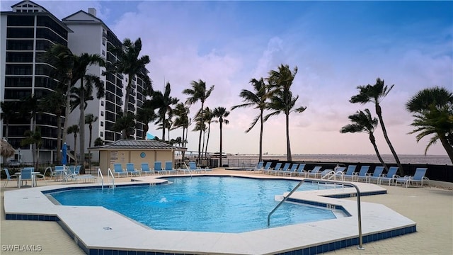 pool at dusk featuring a patio