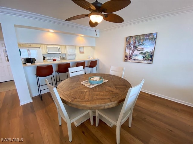 dining space featuring ceiling fan, dark hardwood / wood-style floors, and ornamental molding