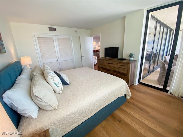 bedroom featuring access to exterior, hardwood / wood-style flooring, and a closet