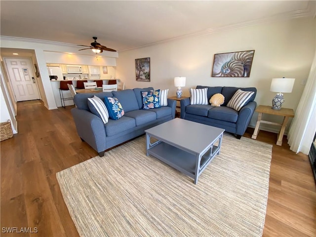 living room featuring hardwood / wood-style floors, ceiling fan, and ornamental molding