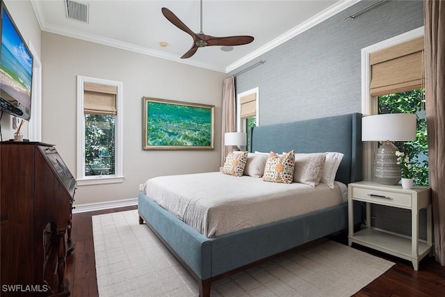 bedroom featuring hardwood / wood-style flooring, ceiling fan, and crown molding