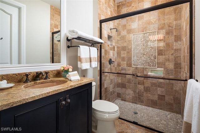 bathroom with vanity, toilet, and a shower with shower door