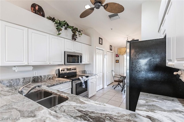 kitchen with sink, stainless steel appliances, light stone counters, lofted ceiling, and white cabinets