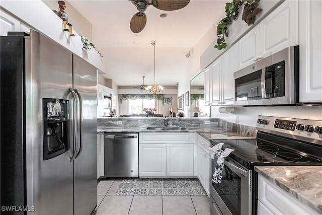 kitchen featuring light stone counters, stainless steel appliances, sink, light tile patterned floors, and white cabinetry