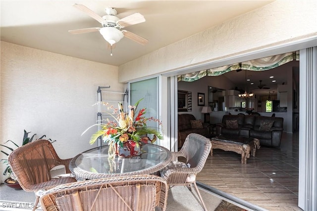 exterior space featuring ceiling fan with notable chandelier