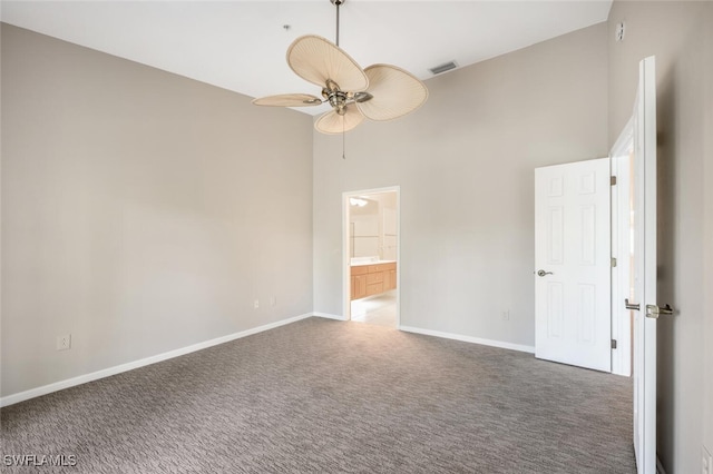 empty room with ceiling fan, high vaulted ceiling, and dark carpet