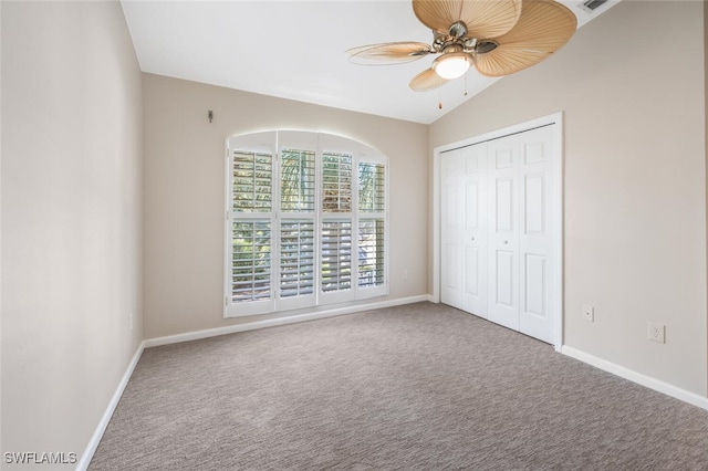 unfurnished bedroom with carpet flooring, a closet, ceiling fan, and vaulted ceiling