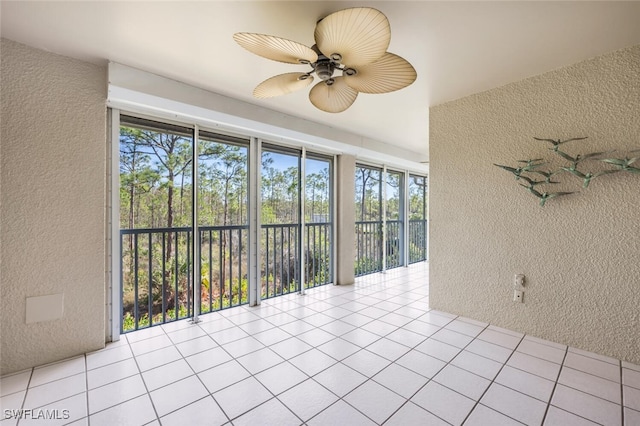 unfurnished sunroom with ceiling fan