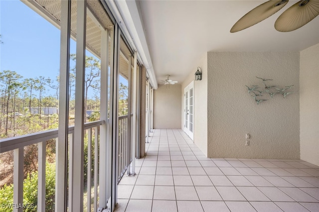 unfurnished sunroom with ceiling fan