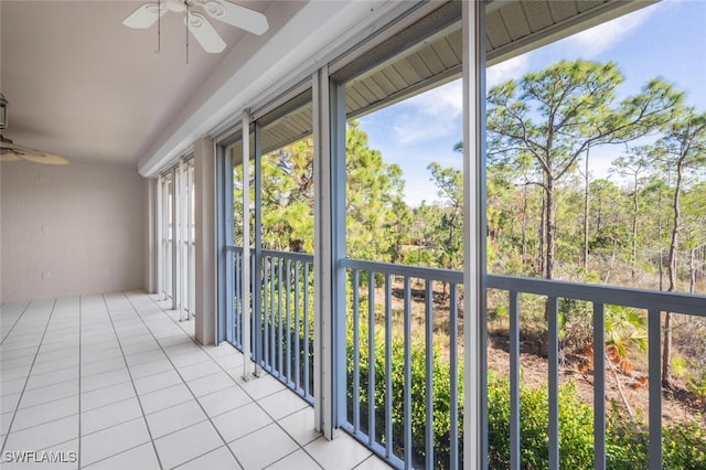 unfurnished sunroom featuring ceiling fan and plenty of natural light