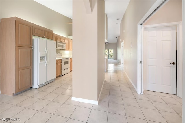 kitchen with white appliances, light tile patterned floors, and lofted ceiling