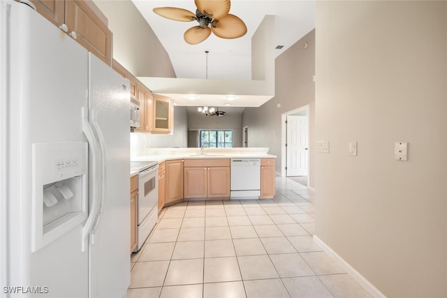 kitchen featuring white appliances, kitchen peninsula, light brown cabinetry, light tile patterned floors, and ceiling fan with notable chandelier