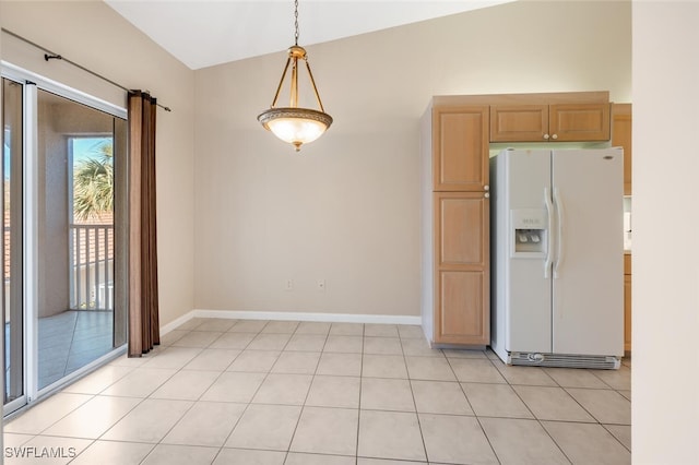 kitchen featuring decorative light fixtures, white fridge with ice dispenser, and light tile patterned floors