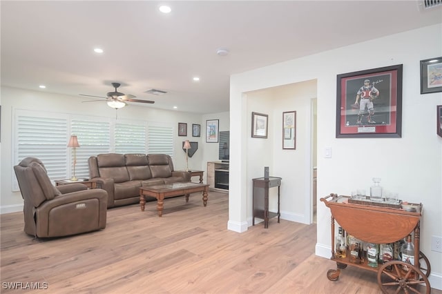 living room featuring ceiling fan and light hardwood / wood-style floors