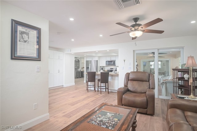 living room featuring light hardwood / wood-style flooring and ceiling fan