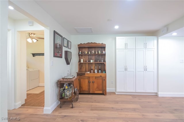 hallway featuring washing machine and clothes dryer and light wood-type flooring