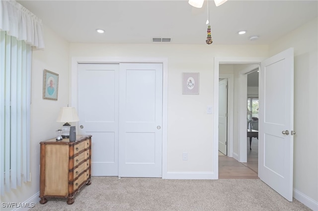 bedroom with light colored carpet and a closet